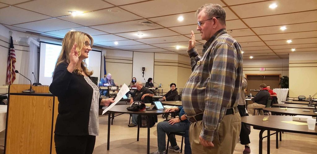 Eric Devine holding his right hand up, taking an oath of service.